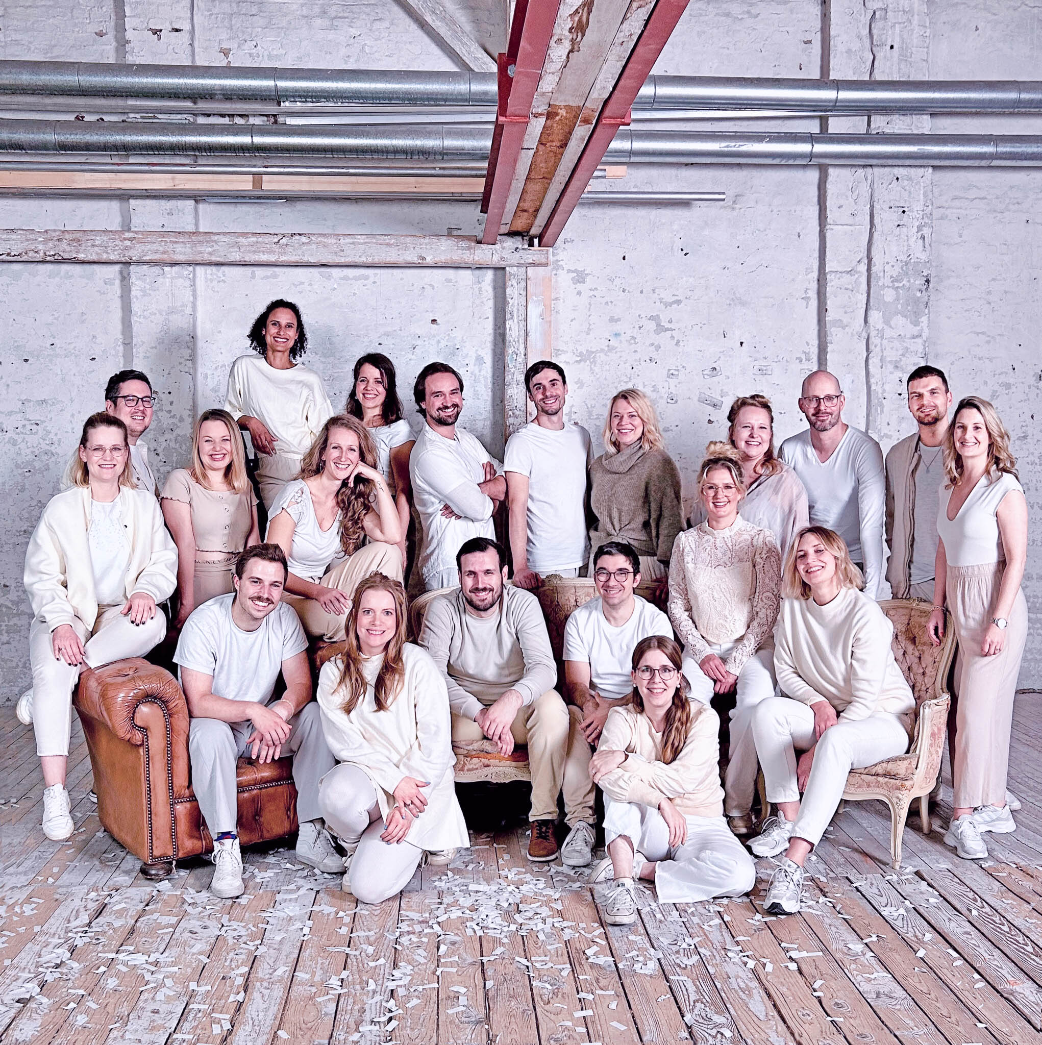 Künstlerisches Gruppenfoto vom Hamburger Popchor new choir on the block im Studio, helle Outfits in Beige- und Weißtönen